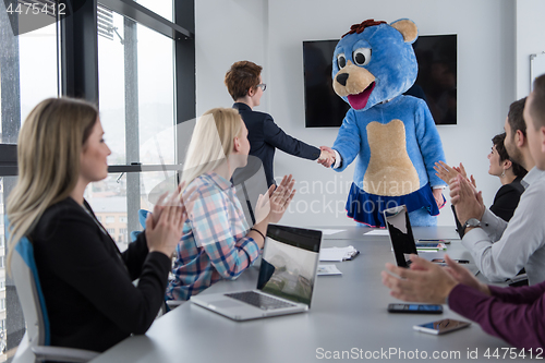 Image of boss dresed as bear having fun with business people in trendy of