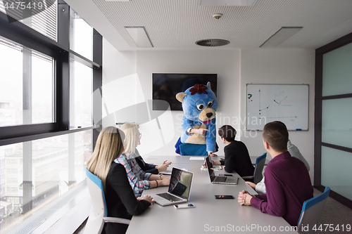 Image of boss dresed as bear having fun with business people in trendy of