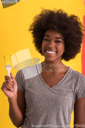 Image of black woman painting wall