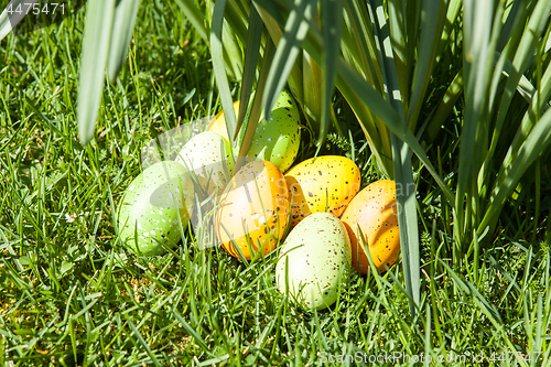 Image of colored Easter eggs hidden in flowers and grass