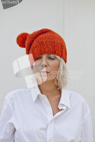 Image of Pretty young woman in warm orange beanie.