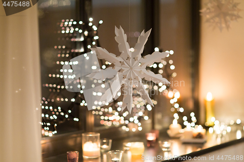 Image of paper snowflake decoration hanging on window