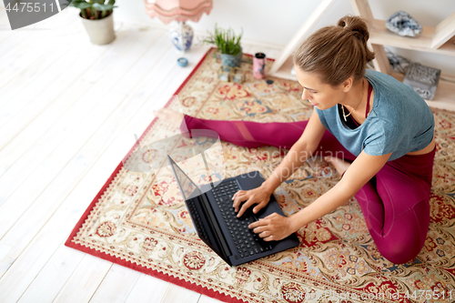 Image of woman with laptop computer at yoga studio