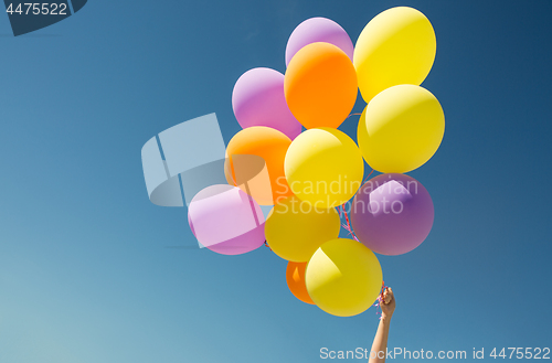 Image of close up of colorful helium balloons in blue sky