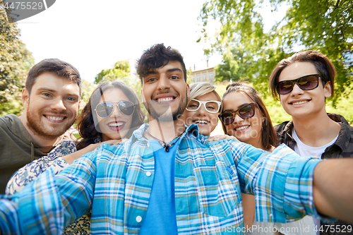 Image of happy smiling friends taking selfie at summer park