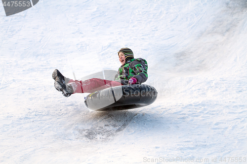 Image of Happy boy with snow tube