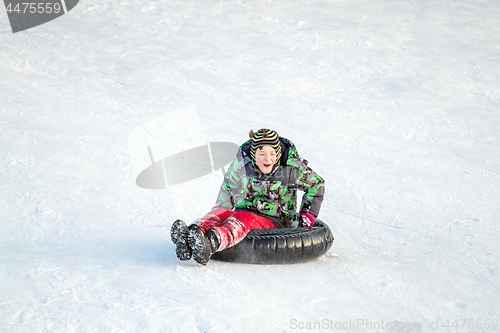 Image of Happy boy with snow tube