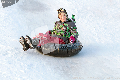 Image of Happy boy with snow tube