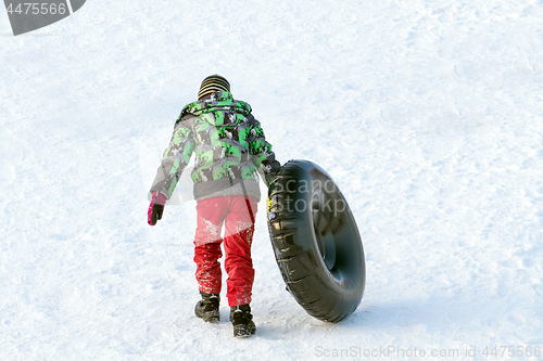 Image of Happy boy with snow tube