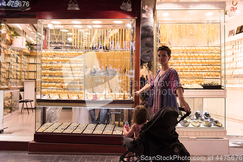 Image of mother with  little girl in a stroller in front of  jewelry shop