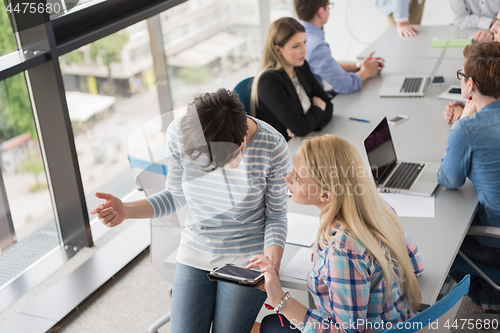 Image of Pretty Businesswomen Using Tablet In Office Building during conf