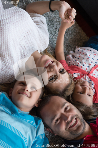 Image of happy family lying on the floor