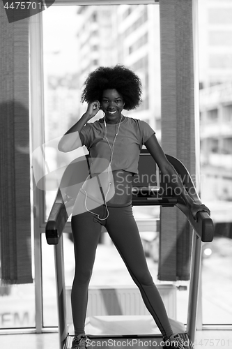 Image of afro american woman running on a treadmill