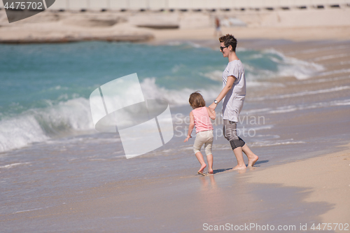 Image of mother and daughter running on the beach