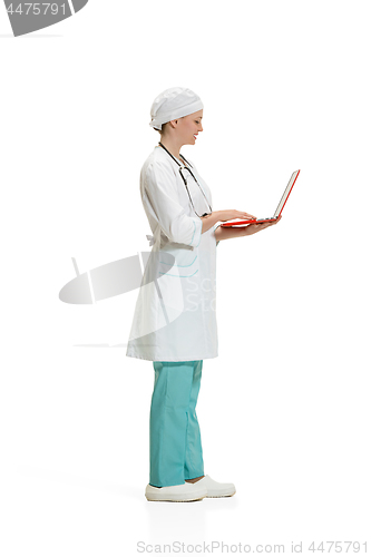 Image of Beautiful young woman in white coat posing at studio. Full length studio shot isolated on white.
