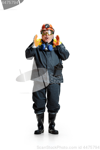 Image of The studio shot of senior bearded male miner standing at the camera on a white background.