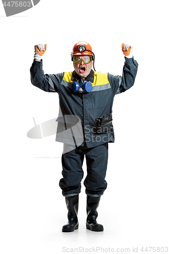 Image of The studio shot of senior bearded male miner standing at the camera on a white background.