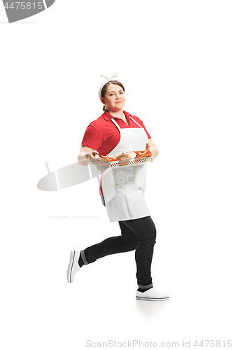 Image of Portrait of cute smiling woman with pastries in her hands in the studio, isolated on white background