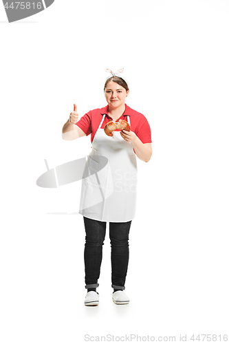 Image of Portrait of cute smiling woman with pastries in her hands in the studio, isolated on white background