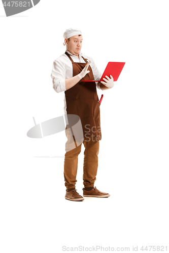 Image of Surprised butcher posing with a laptop isolated on white background