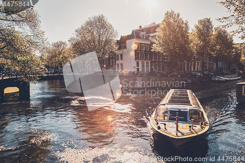 Image of Amsterdam canal with tourist boat