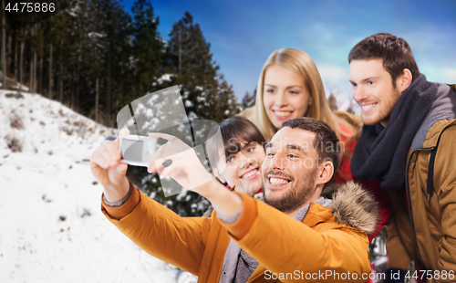 Image of happy friends with camera over winter background