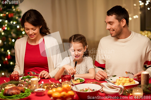 Image of happy family having christmas dinner at home