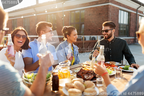 Image of happy friends with drinks or bbq party on rooftop