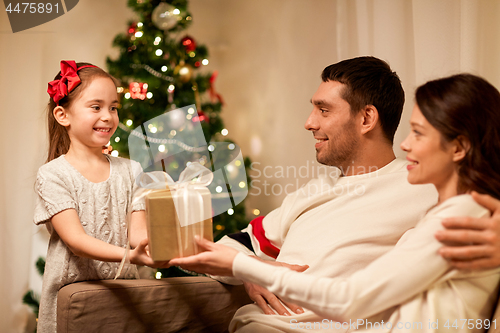 Image of happy family with christmas present at home