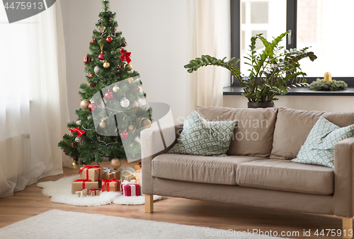 Image of christmas tree, gifts and sofa at cozy home