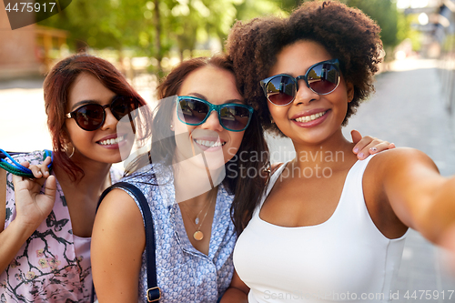 Image of happy young women in sunglasses at summer park