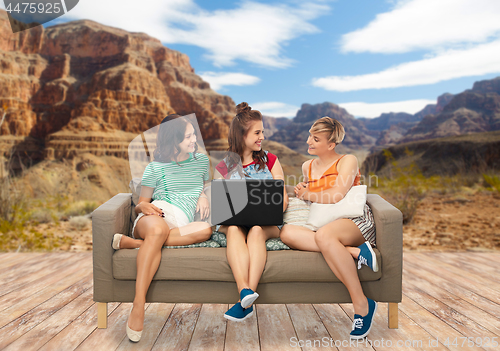 Image of friends with laptop computer over grand canyon