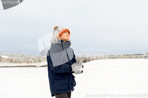 Image of happy little boy playing with snow in winter