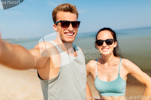 Image of couple taking selfie by smartphone on beach