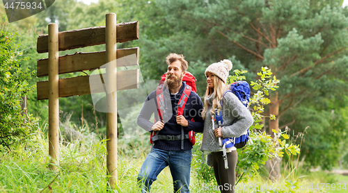 Image of couple of travelers with backpacks at signpost