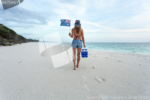 Image of Aussie beach culture  Woman walking on beach with esky