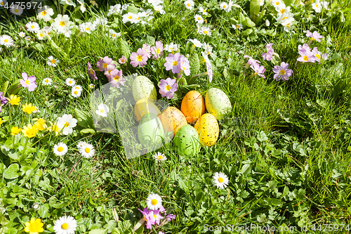 Image of colored Easter eggs hidden in flowers and grass