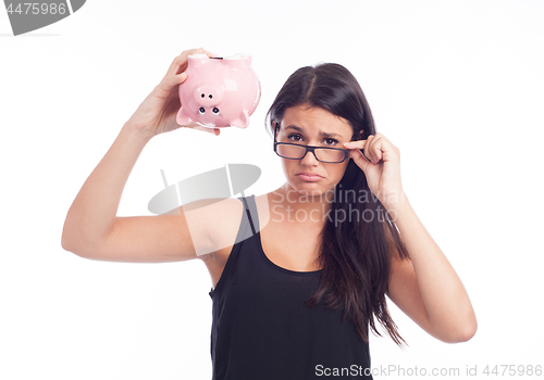 Image of Young woman worried with a piggy bank