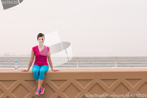 Image of young woman sitting after a successful training run