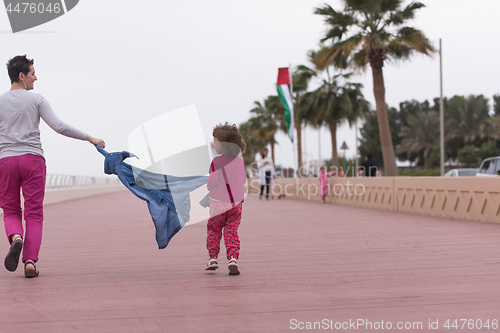 Image of mother and cute little girl on the promenade by the sea