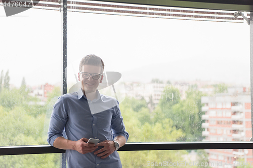 Image of Businessman Standing In A Modern Building Near The Window With P