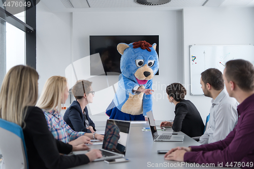 Image of boss dresed as bear having fun with business people in trendy of