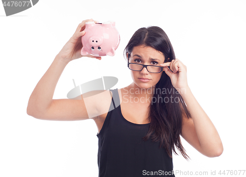 Image of Young woman worried with a piggy bank