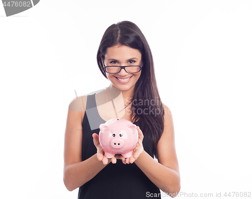 Image of Young woman with glasses happy with piggy bank