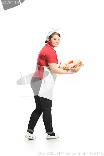 Image of Portrait of cute smiling woman with pastries in her hands in the studio, isolated on white background