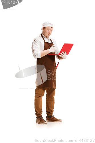 Image of Serious butcher posing with a laptop isolated on white background