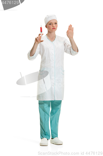 Image of beautiful young woman doctor in medical robe holding syringe in hand.