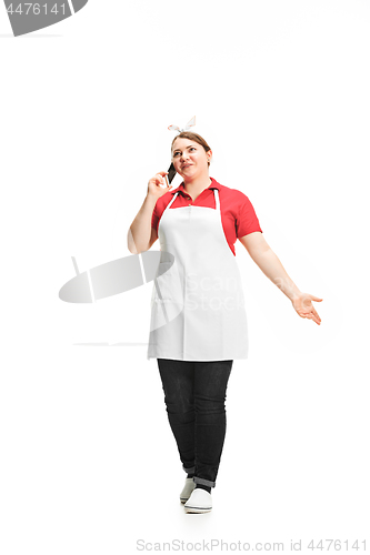 Image of Portrait of cute smiling woman with mobile phone in her hands in the studio, isolated on white background