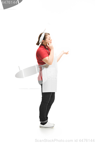 Image of Portrait of cute smiling woman with mobile phone in her hands in the studio, isolated on white background