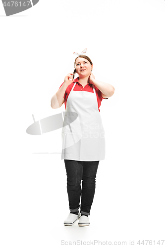 Image of Portrait of cute smiling woman with mobile phone in her hands in the studio, isolated on white background